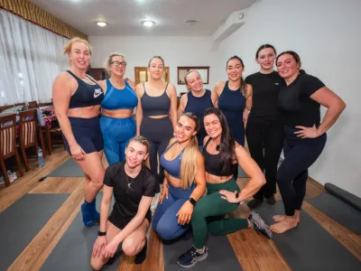 10 women take a group photo in a yoga class